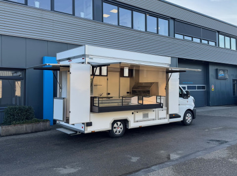 Zijaanzicht van een verkoopwagen zelfrijder voor loempia's met geopende luifel