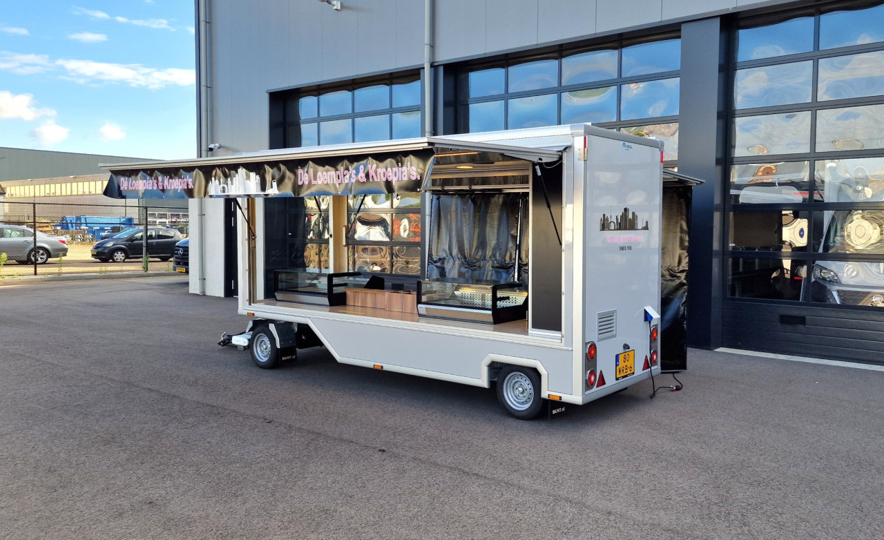 Zijaanzicht van een aanhangwagen voor loempia's en kroepia's met geopende luifel