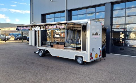 Zijaanzicht van een aanhangwagen voor loempia's en kroepia's met geopende luifel