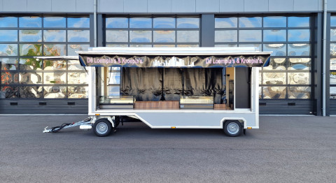 Zijaanzicht van een aanhangwagen voor loempia's en kroepia's met geopende luifel