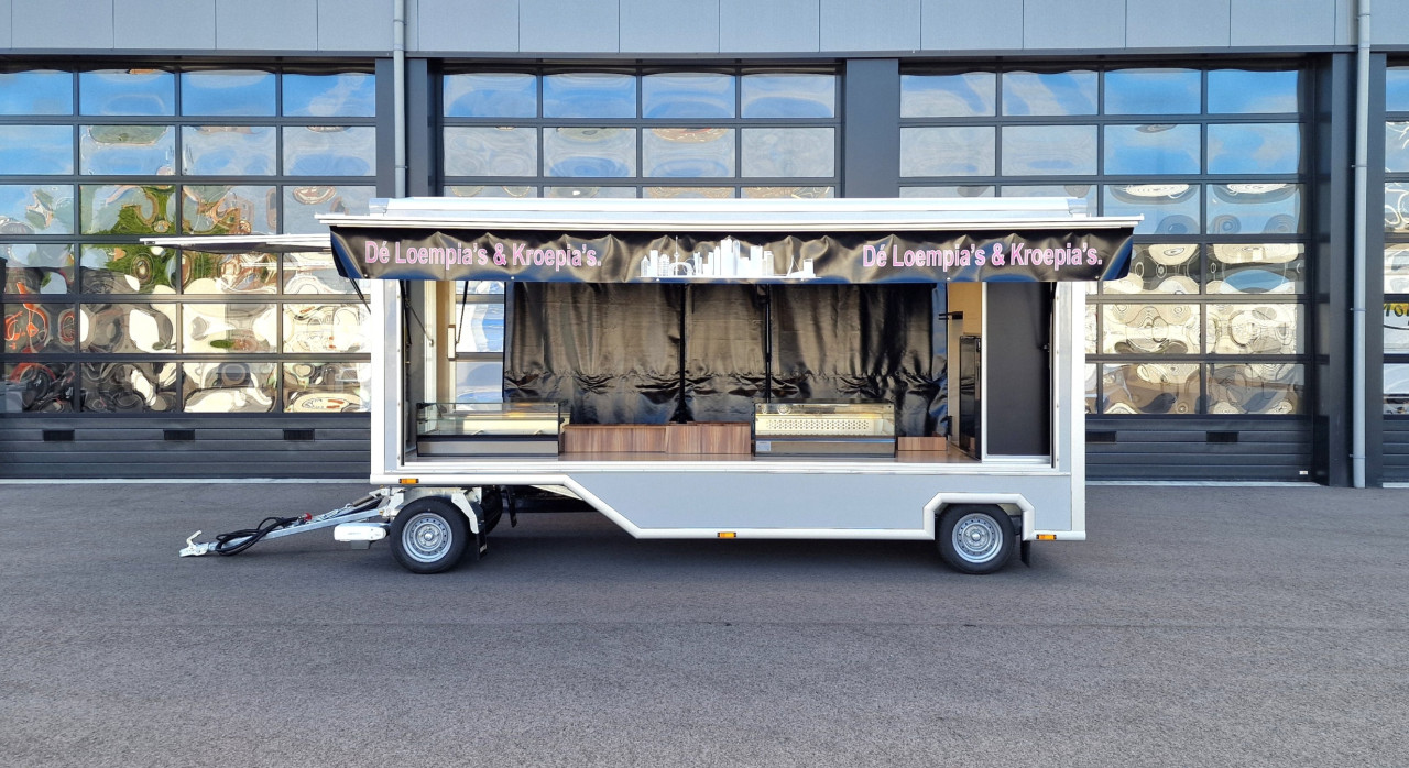 Zijaanzicht van een aanhangwagen voor loempia's en kroepia's met geopende luifel