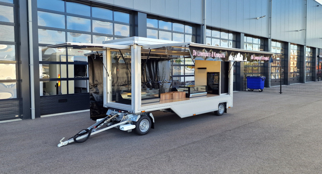 Zijaanzicht van een aanhangwagen voor loempia's en kroepia's met geopende luifel