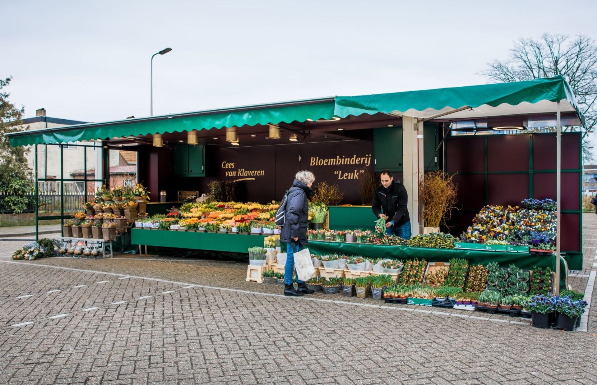 Volledig uitgestalde aanhangwagen voor bloemen, op een parkeerterrein
